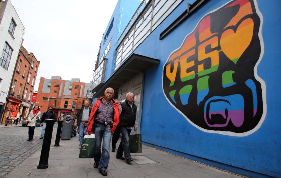 Ciudadanos de Dublín pasan por delante de un cartel a favor del sí en el referendum sobre el matrimonio gay