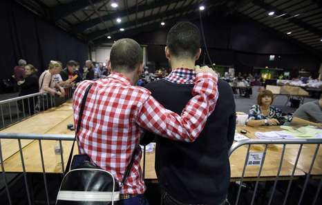 A couple watch the count at a count centre in Dublin following the vote on same-sex marriage in Ireland on May 23, 2015. Counting got under way today in Ireland's historic referendum on same-sex marriage, with thousands of people, some of whom rushed home from living abroad to vote, gathering to hear the results. AFP PHOTO /  Paul Faith