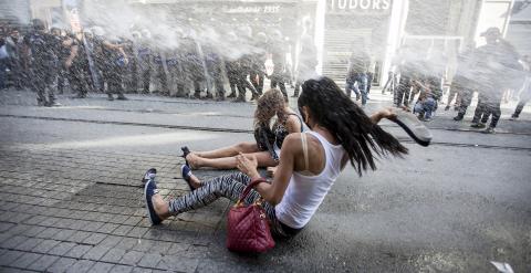 Activistas del colectivo LGTB reciben el impacto del cañón de agua de una tanqueta policial que ha disparado contra ellos este domingo en Estambul, Turquía