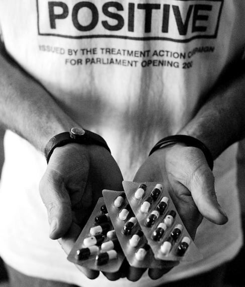 Un joven sostiene varios fármacos contra el VIH
