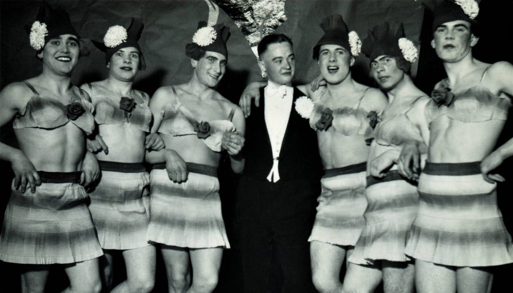 Hombre en esmoquin rodeado de seis travestis. Alemania, invierno de 1937