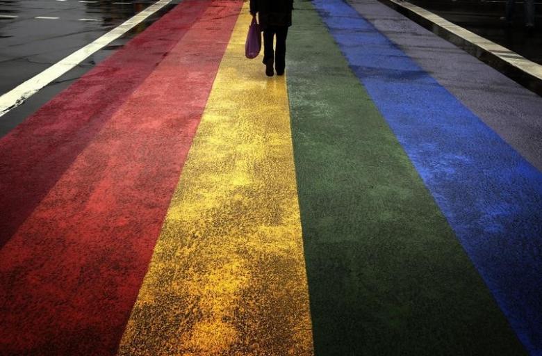 A pedestrian walks across a rainbow pedestrian crossing painted on Sydney's Oxford street, the city's main gay district April 4, 2013. REUTERS/David Gray