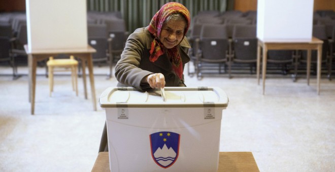 Una mujer vota en un colegio electoral en un referéndum sobre el derecho a casarse y adoptar niños de parejas del mismo sexo, en Sora, Eslovenia