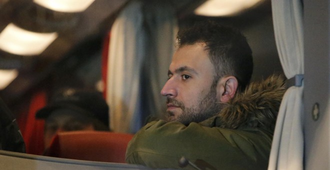 Un refugiado se sienta dentro de un autobús que llega desde la ciudad bávara de Landshut al edificio Cancillería en Berlín