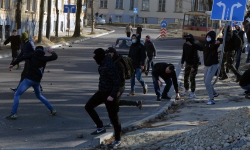Masked right-wing militants throw rocks during an attack against gay people on March 19, 2016 in Lviv. Some 200 right-wing militants on March 19, 2016 attacked dozens of gay people with smoke bombs and stones in Lviv, a nationalist bastion in western Ukraine, an AFP journalist witnessed. The attack occurred as representatives of the lesbian, gay, bisexual and transgender (LGBT) community left a Lviv hotel which is hosting a gay rights event this weekend.  / AFP / YURIY DYACHYSHYN        (Photo credit should read YURIY DYACHYSHYN/AFP/Getty Images)